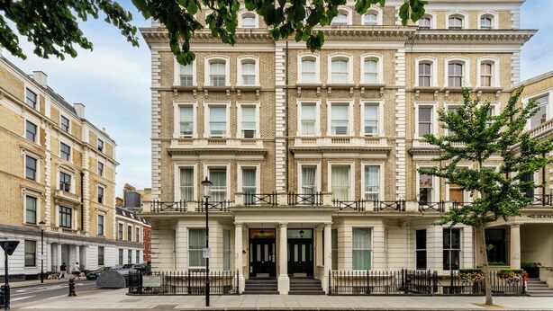 A multi-story building with a classic architectural style, featuring a symmetrical facade, large windows, and a central entrance with steps. - Cleveland Residences Kensington (London)