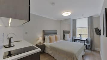 Une chambre d’hôtel moderne, équipée d’un lit, d’une table de chevet, d’une lampe et offrant une vue sur l’extérieur.