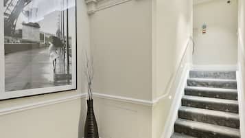Una gran escala amb motllures ornamentals i una fotografia en blanc i negre a la paret.