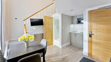 A modern kitchen with white cabinets, a built-in oven, and a microwave.