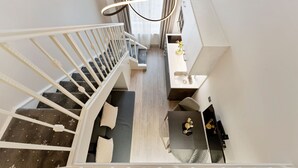 A modern interior with a staircase, a dining area, and a kitchen. - Cleveland Residences Kensington (London)