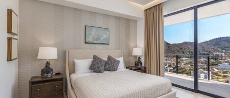A modern bedroom with a large bed, two bedside tables, a view of a cityscape through floor-to-ceiling windows, and a herringbone-patterned wall.