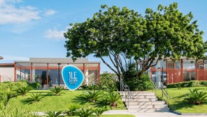 Een modern gebouw met een bord waarop “ILE DE PIPA RESORT” staat.