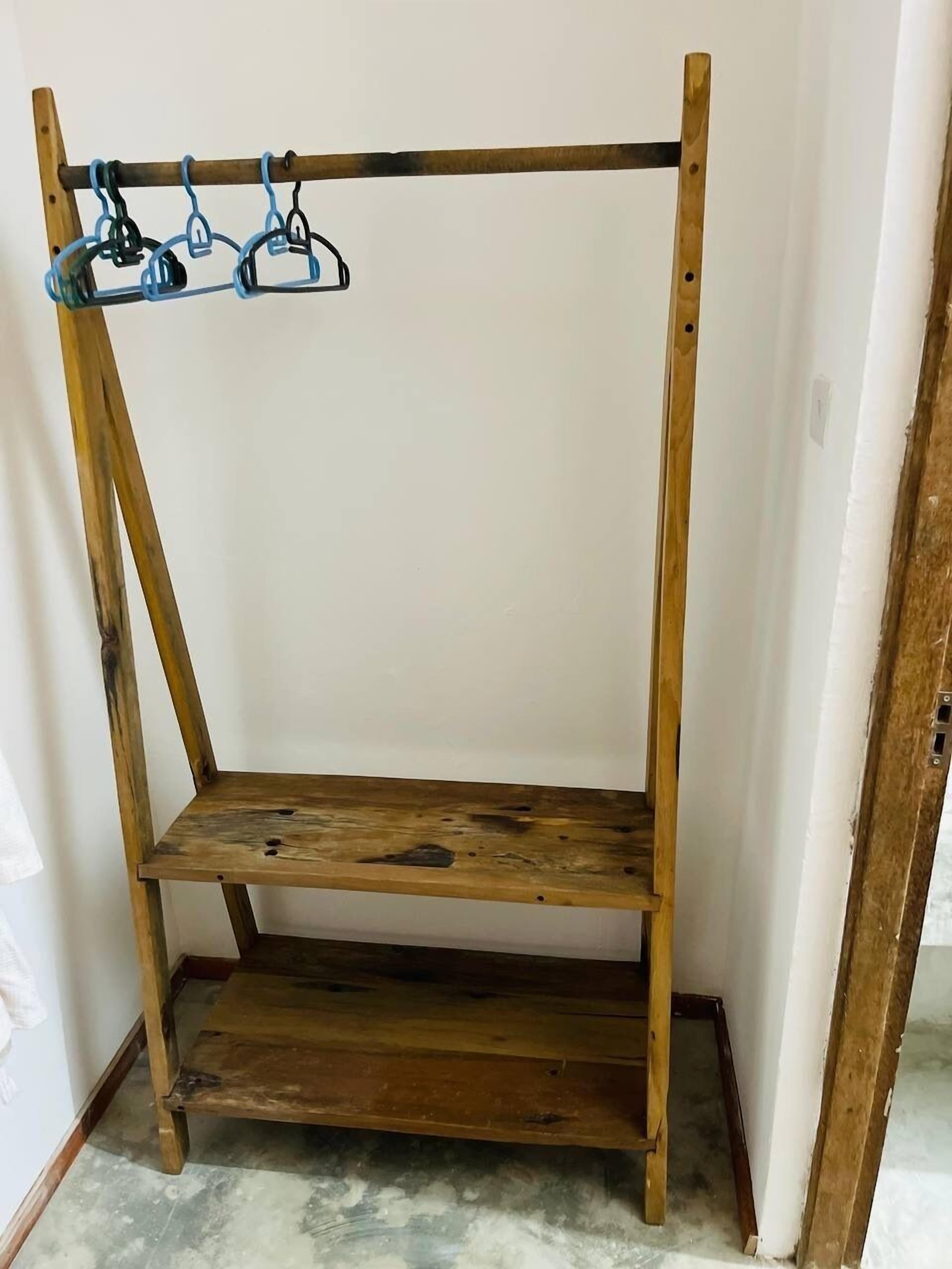 A wooden shelf unit with three shelves and a hanging rack.