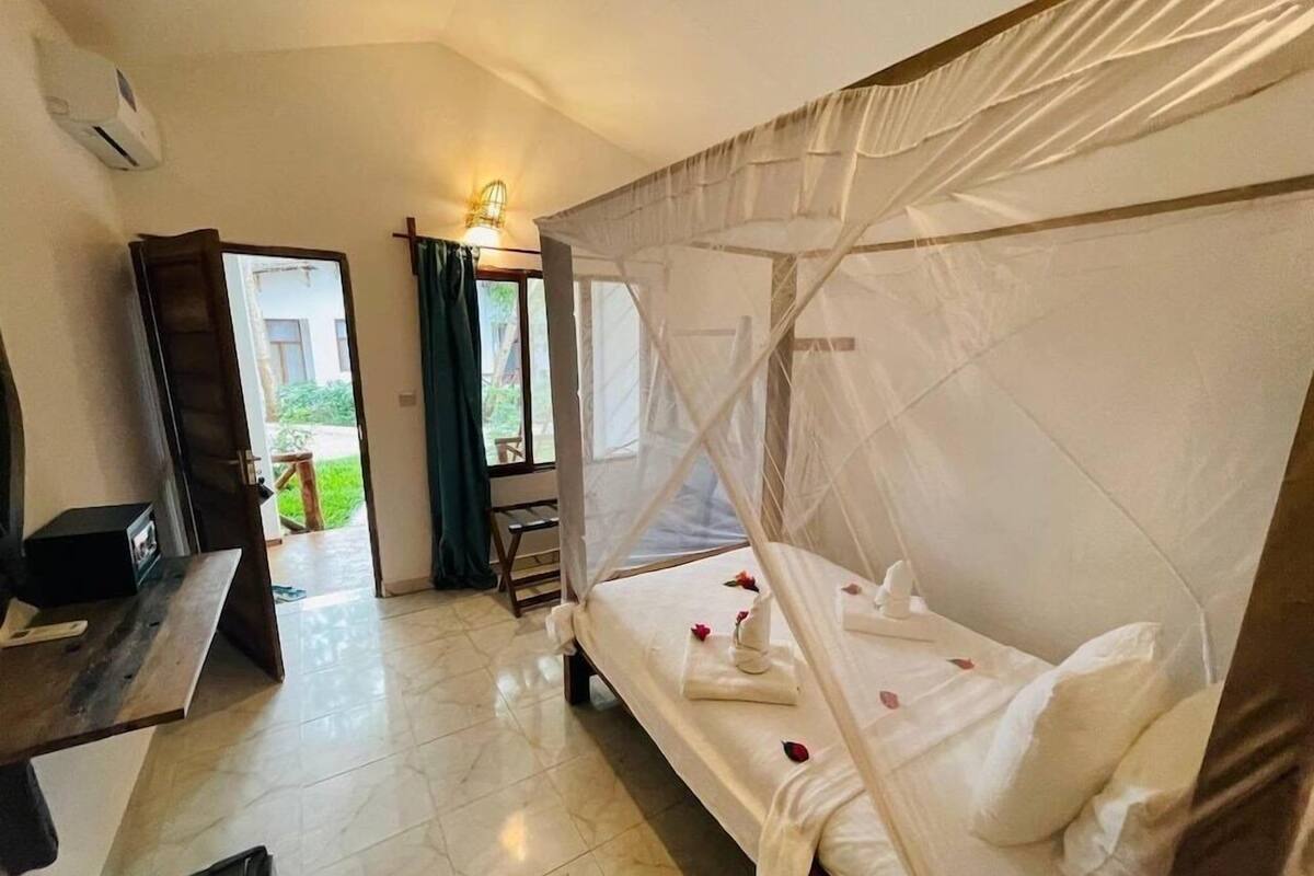 A hotel room with a bed, a desk, and a chair.