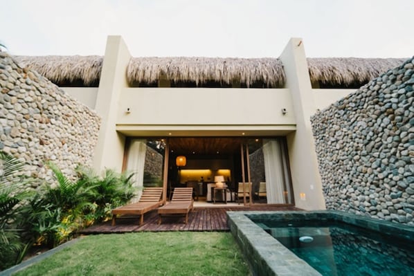 A resort with a thatched-roof entrance, a pool, and a well-maintained garden. - Naio Hotel y Villas (Dibulla)