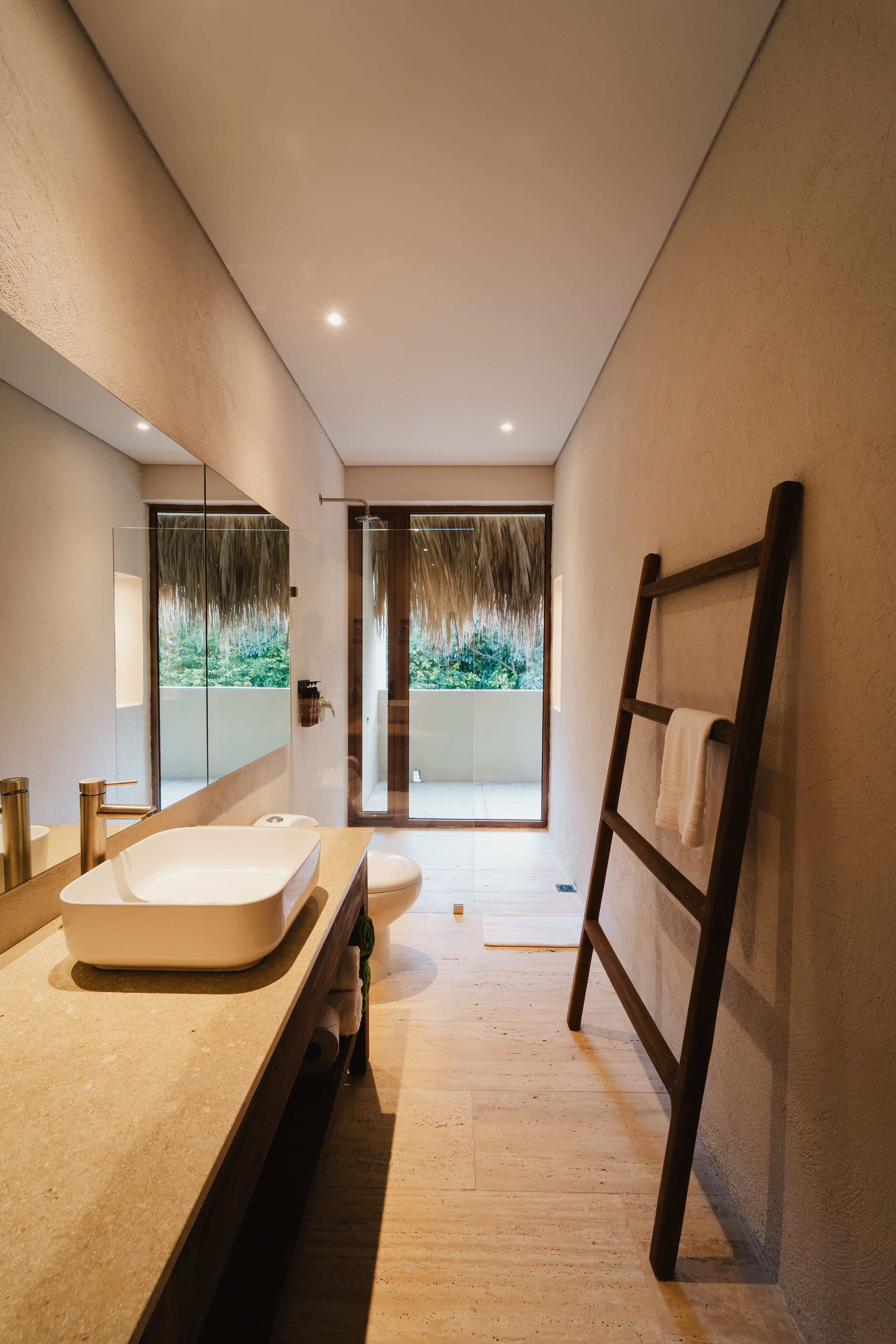 Un baño moderno con un espejo grande, una bañera y una zona de ducha.