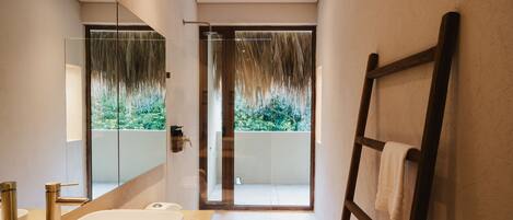 Un baño moderno con un espejo grande, una bañera y una zona de ducha.