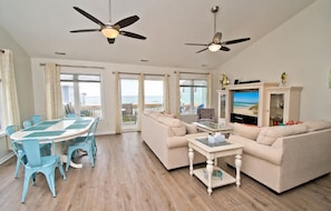 A living room with a sofa, coffee table, TV, and a balcony with a view.