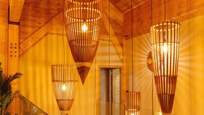 Un intérieur en bois avec trois luminaires suspendus et un escalier.
