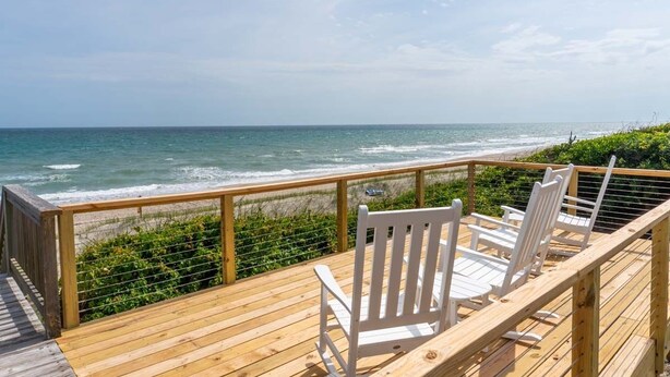 A wooden deck with white chairs overlooking the ocean. - Beach Thyme, Oceanfront House in Indian Beach, NC! (Indian Beach)