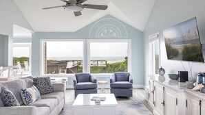 A living room with a ceiling fan, two patterned armchairs, a sofa, a coffee table, and a TV on a cabinet. - Beach Thyme, Oceanfront House in Indian Beach, NC! (Indian Beach)