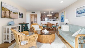 A living room with wicker furniture, a round coffee table, and a light blue sofa.
