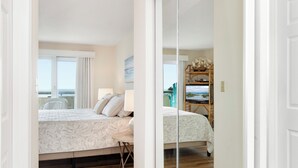 A bedroom with a bed, bedside table, and a window with curtains.
