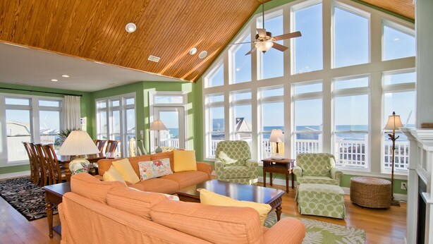 A spacious living room with a high ceiling, large windows, and a view of the ocean. - Bermuda House, Almost Oceanfront House in Emerald Isle, NC! (Emerald Isle)