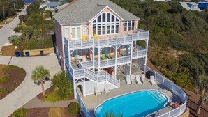 A two-story building with a pool, balconies, and a view of the ocean. - Bermuda House, Almost Oceanfront House in Emerald Isle, NC! (Emerald Isle)