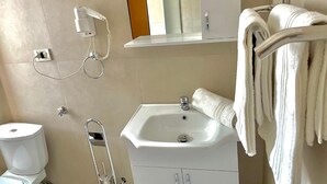 A bathroom with a toilet, sink, and towel rack. - Algo Hotel (Tirana)