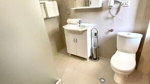 A bathroom with a toilet, sink, and a hand dryer mounted on the wall. - Algo Hotel (Tirana)