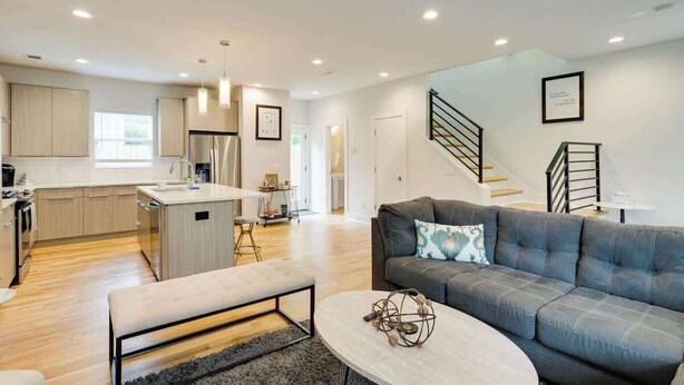 A modern apartment with a kitchen, living area, and staircase.