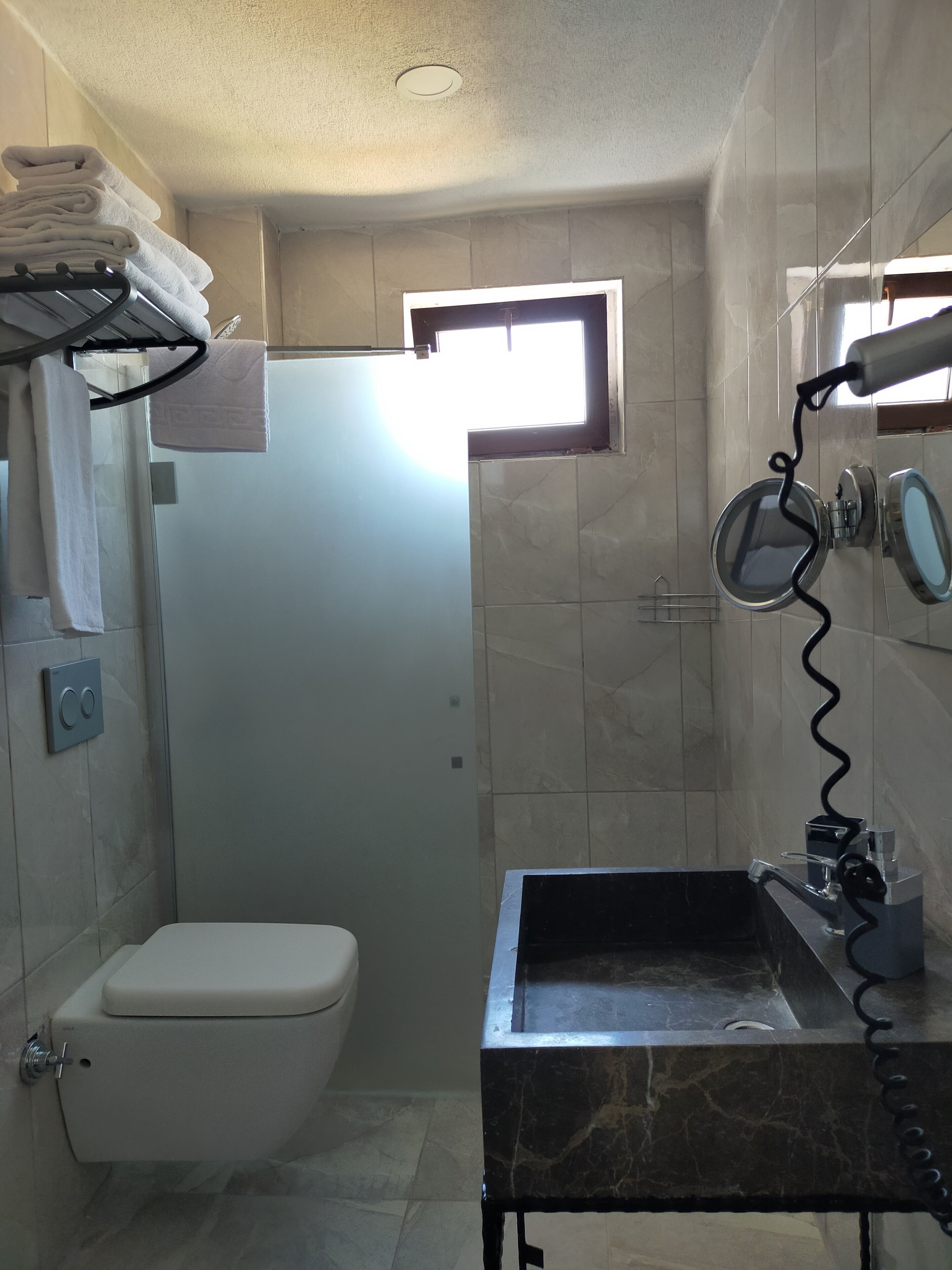 A compact bathroom with a toilet, a sink, and a shower.