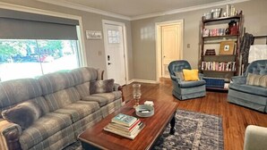 A living room with a sofa, armchairs, a coffee table, and a bookshelf. - The Vandalia House - Midcentury Rodeo Meets Midtown, University of Tulsa, and Expo Center (Tulsa)