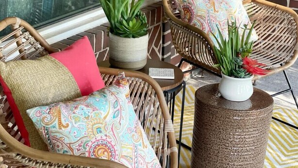 Wicker chairs with colorful cushions, a potted plant, and a textured stool on a patterned floor. - The Vandalia House - Midcentury Rodeo Meets Midtown, University of Tulsa, and Expo Center (Tulsa)