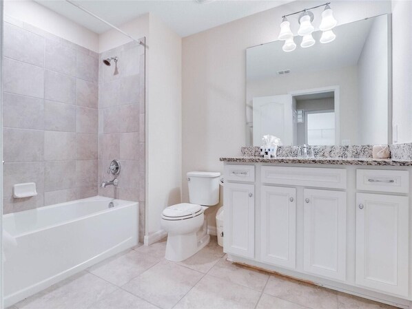 Une salle de bain moderne équipée d’une baignoire, de toilettes et d’un meuble-lavabo.
