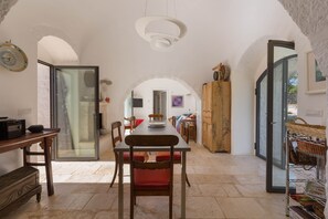 Un vaste espace dédié à la salle à manger, avec une longue table, des chaises et un lustre moderne.