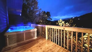 A wooden deck with a hot tub and a railing. -  Mountain View, hot tub, pool table within 30  of downtown and national parks (Gatlinburg)