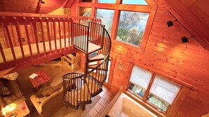 A wooden interior with a spiral staircase, a window with a view of trees, and a bathtub. -  Mountain View, hot tub, pool table within 30  of downtown and national parks (Gatlinburg)