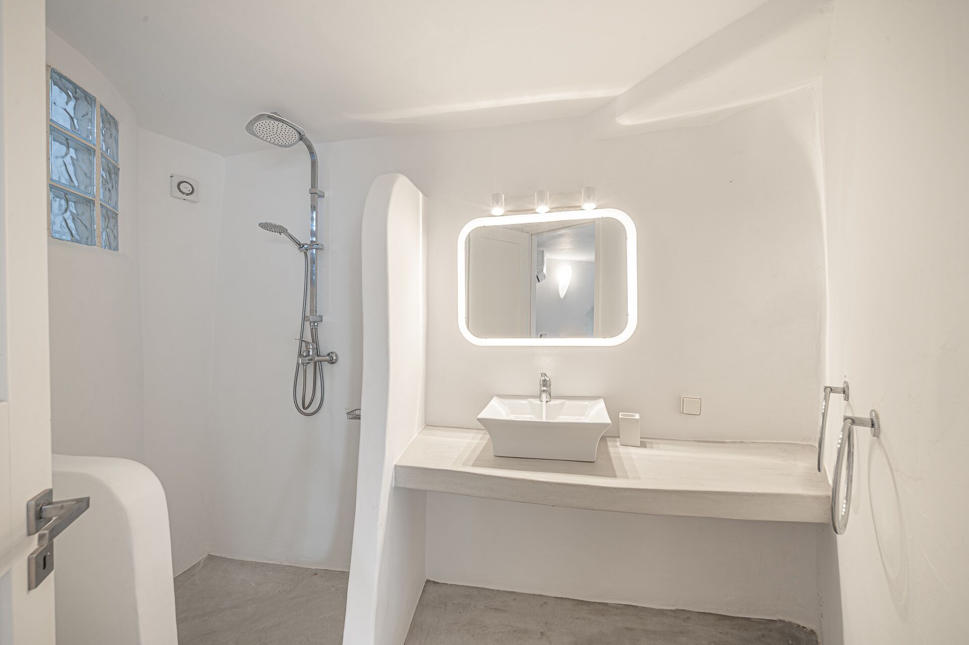 A bathroom with a shower, a sink, and a mirror.