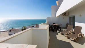 Un balcón con mesa y sillas, con vista al mar.