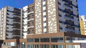 A multi-story residential building with a modern design, featuring balconies and large windows. - Apartamento acesso ao diRoma Acqua Park (Caldas Novas)