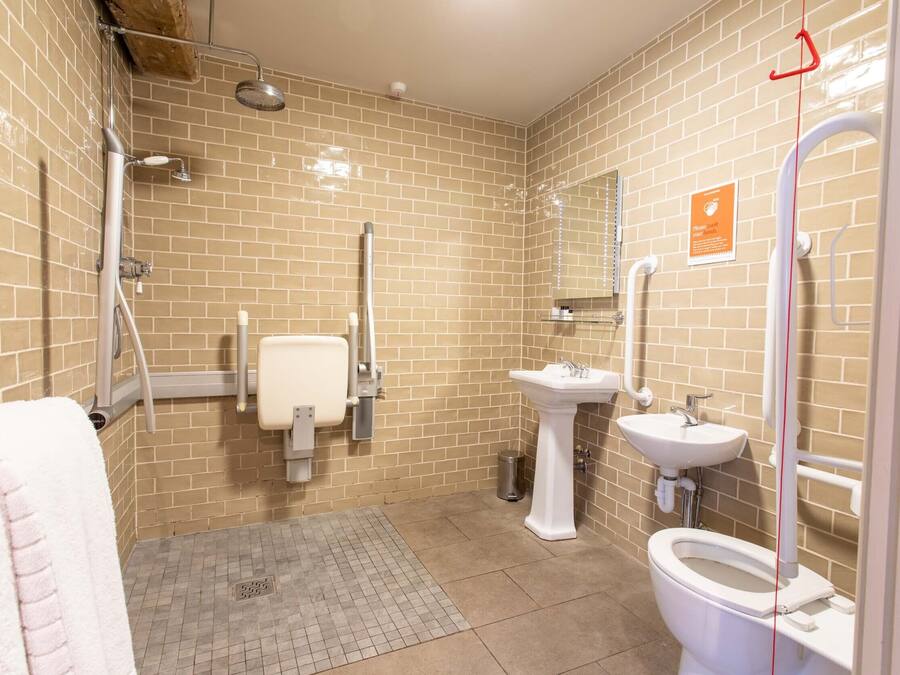 A bathroom with a toilet, bidet, sink, and shower.