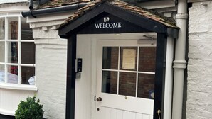 A white building with a black "WELCOME" sign above a door. - 1777 The Albion (Wimborne)