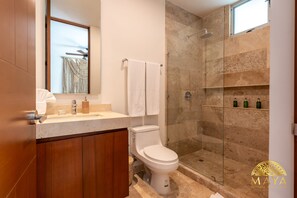 Een moderne badkamer met toilet, wastafel en douche.