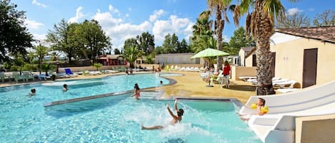 A swimming pool with multiple lanes, lounge chairs, and palm trees.
