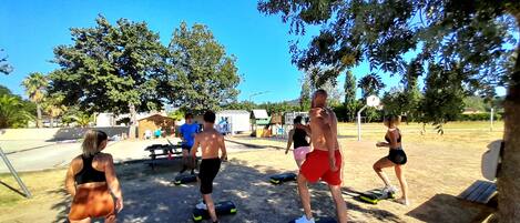 Un grupo de personas haciendo ejercicio al aire libre usando equipo de gimnasia.