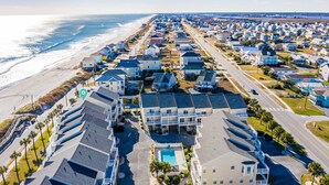 A coastal residential area with houses, a beach, and a swimming pool.