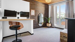 Eine moderne Küche mit Holzbalkendecke, einer Bar, einem großen Spiegel und Blick ins Freie durch eine Glastür.