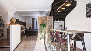 Eine moderne Küche mit einer Holztischinsel, Barhocker und einer Topfpflanze.