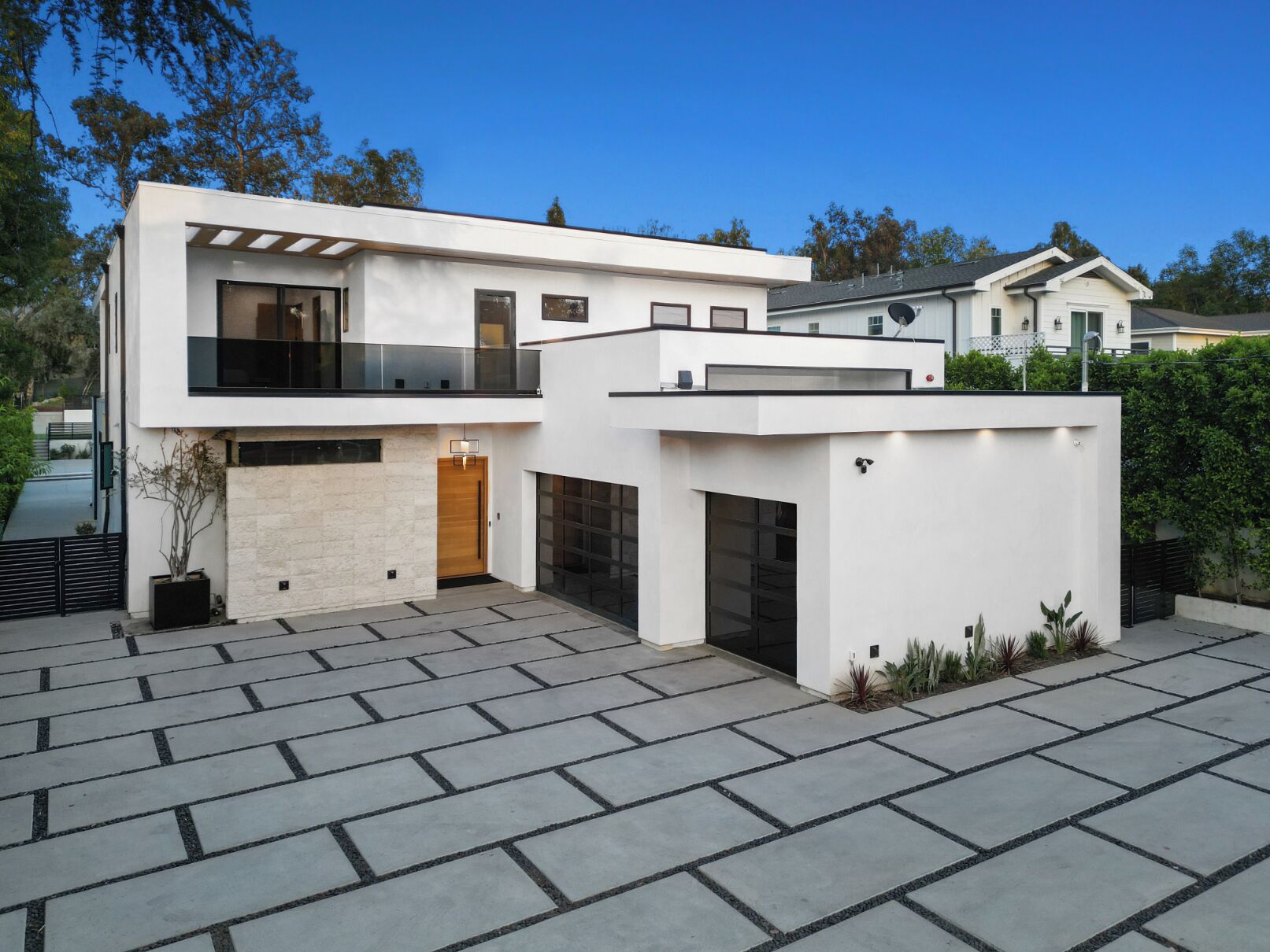 A modern two-story house with a spacious driveway and a garage.