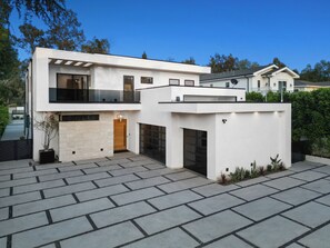 Ein modernes, zweistöckiges Haus mit großzügigem Auffahrt und Garage.