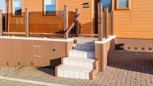 A wooden building with a staircase leading to a door marked "26". - Serenity Sunset (Ilfracombe)