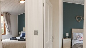 A bedroom with a bed, bedside table, and a nightstand. - Serenity Sunset (Ilfracombe)