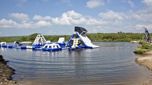 A water park with inflatable structures and a sandy beach.