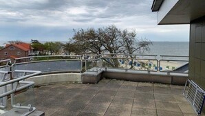 Ein Balkon mit Blick auf das Meer, ein Fliesenboden und ein Geländer.
