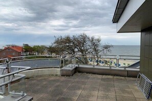 Ein Balkon mit Blick auf das Meer, ein Fliesenboden und ein Geländer.