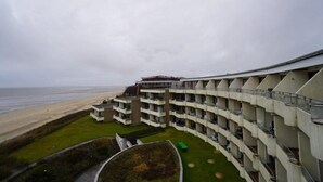 Ein mehrstöckiges Hotel mit Balkonen mit Blick auf einen Strand.