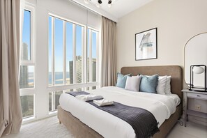 A modern hotel room with a large bed, a view of the city, and a minimalist decor.